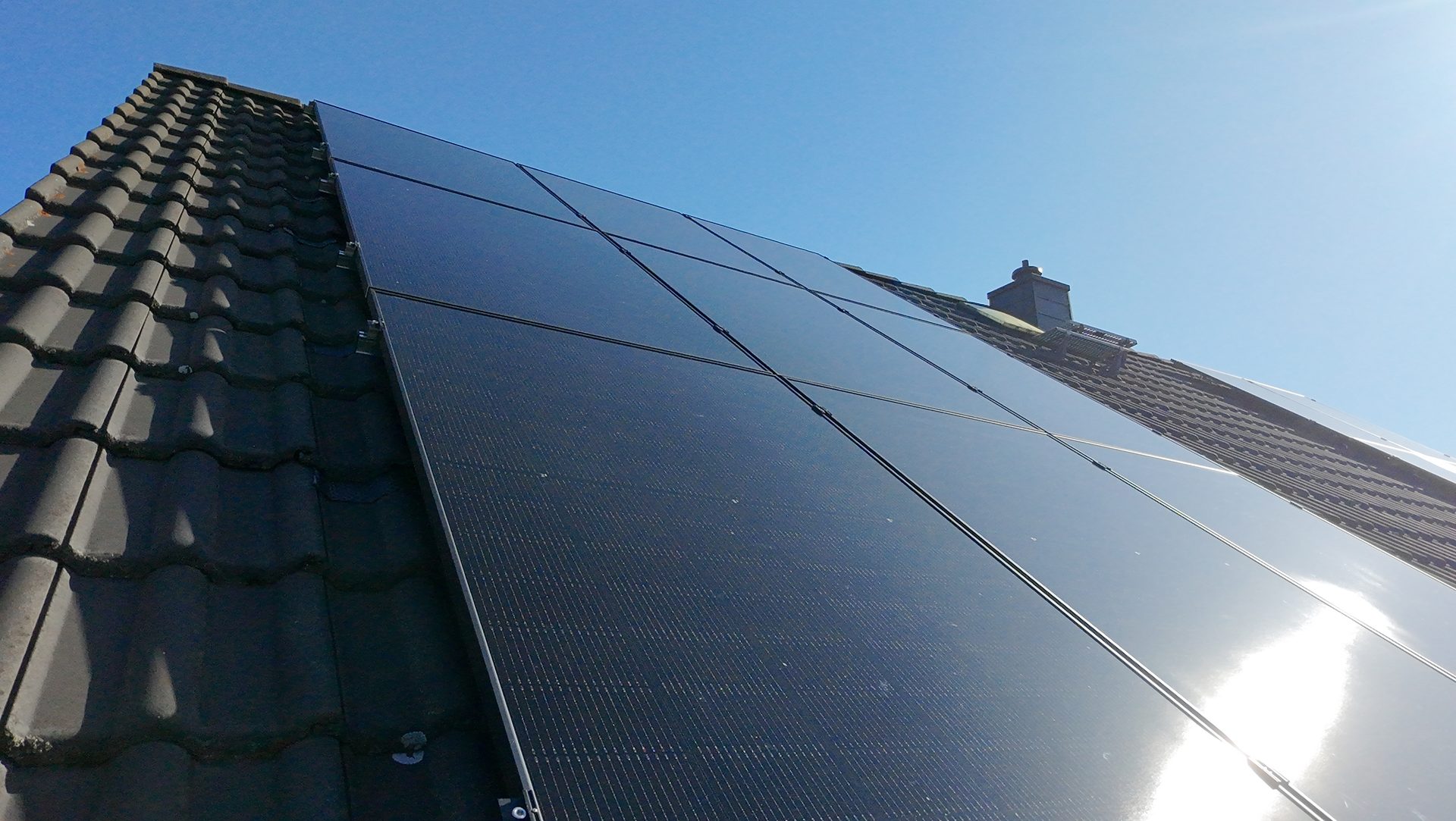 Schwarze Solaranlage vor blauem Himmel
